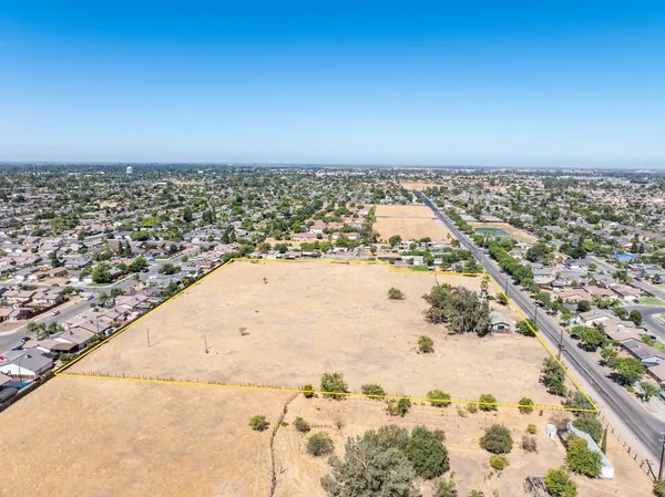 an aerial view of a house with a yard and parking