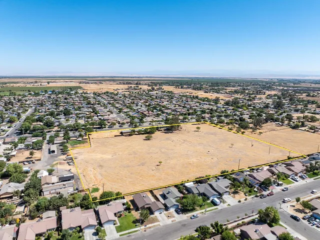 an aerial view of a house with a yard and parking