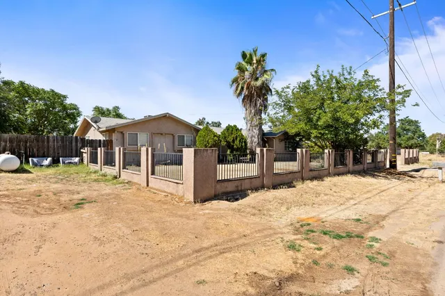 a front view of a house with a yard covered with snow