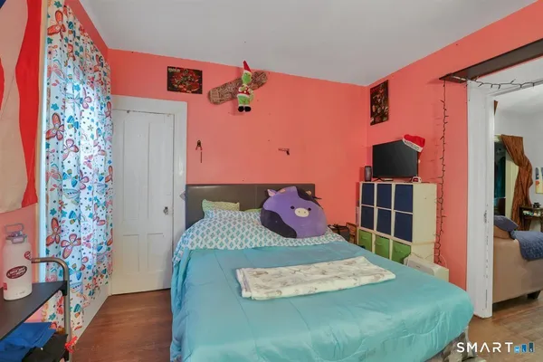 a bedroom with a bed and a flat tv screen on the dresser