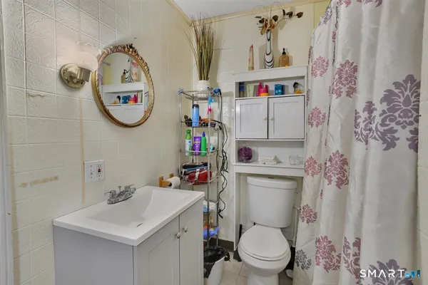 a bathroom with a toilet a sink and a mirror