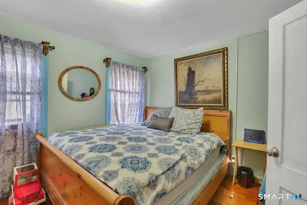 a bedroom with a bed and a painting on the wall