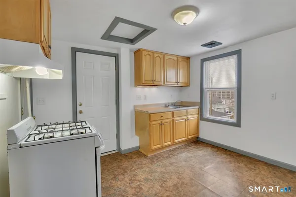 a view of kitchen with stove refrigerator and cabinets