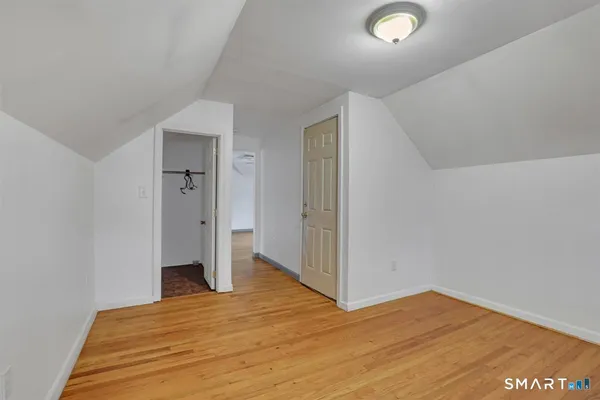 a view of empty room with wooden floor