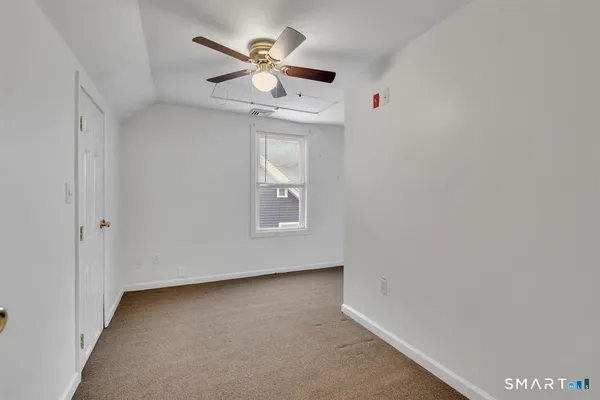 an empty room with a window and a ceiling fan