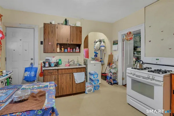 a view of kitchen with stainless steel appliances granite countertop a stove and cabinets