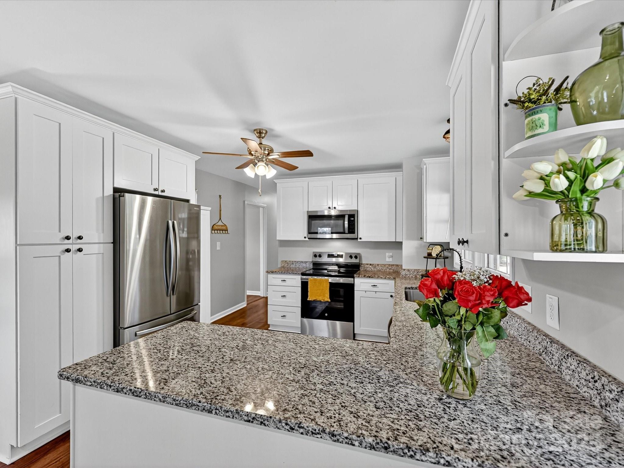 791 Sutton Spring Road York, SC 29745 - Photo 12 of 31 a kitchen with stainless steel appliances granite countertop a refrigerator a sink dishwasher with a dining table and chairs