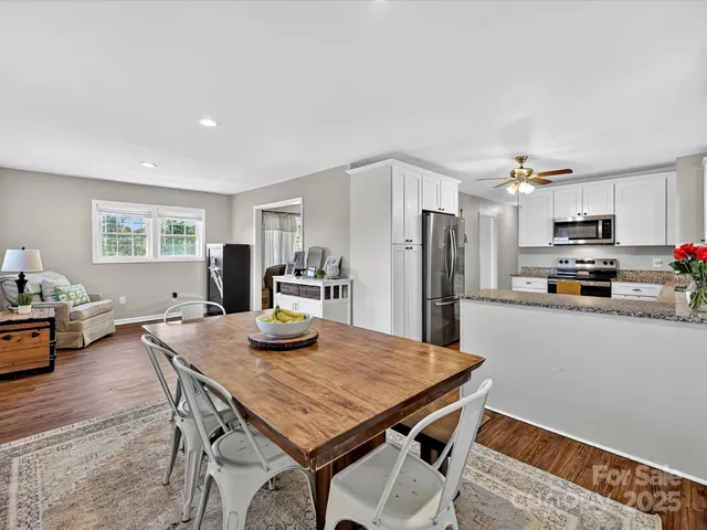 a kitchen with a table chairs refrigerator and microwave
