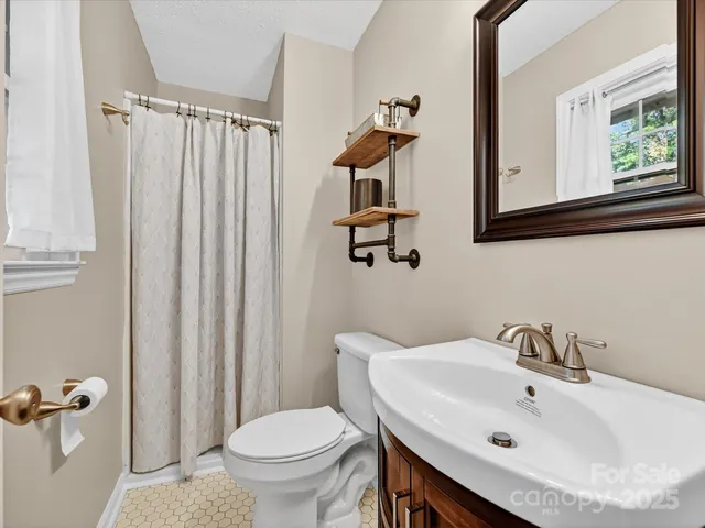 a bathroom with a sink a toilet and a mirror