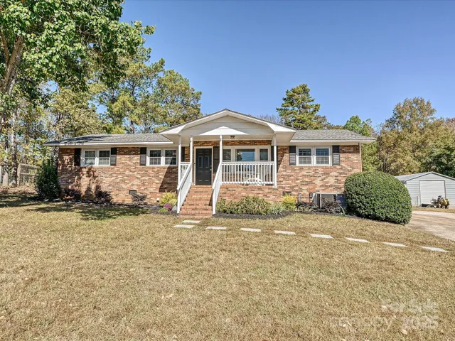 a view of a house with a yard and sitting area