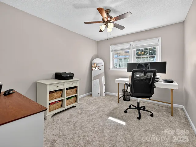 a view of a workspace with furniture and a window