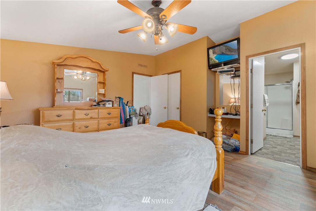16441 Gibson Road Southwest Tenino, WA 98589 - Photo 8 of 26 a spacious bedroom with a bed and a chandelier