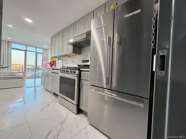 41-62 Bowne Street, Unit 9F Queens, NY 11355 - Photo 15 of 25 a kitchen with stainless steel appliances a refrigerator and a stove top oven