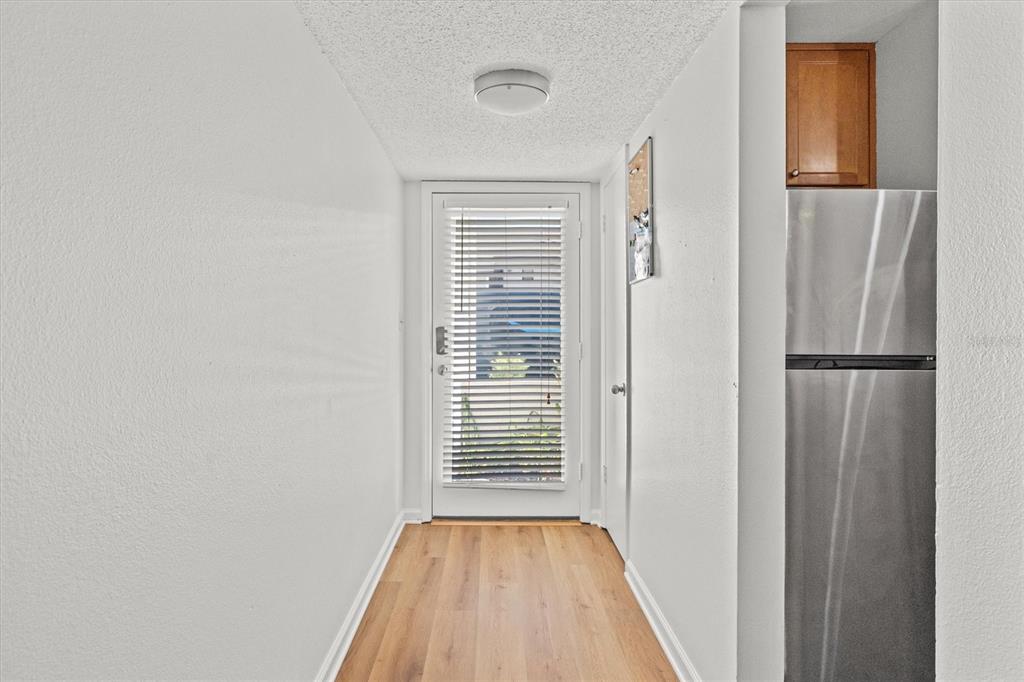 2992 Plaza Terrace Drive, Unit 2992 Orlando, FL 32803 - Photo 3 of 31 a view of a hallway with wooden floor and a bathroom