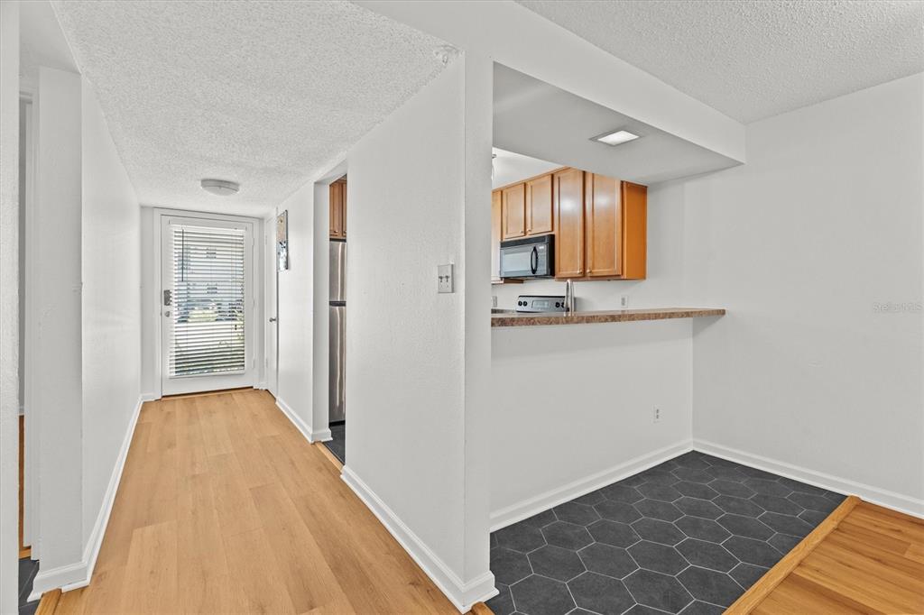 2992 Plaza Terrace Drive, Unit 2992 Orlando, FL 32803 - Photo 4 of 31 a view of a hallway with wooden floor and cabinet