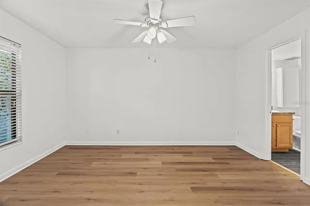a view of a room with wooden floor and a ceiling fan