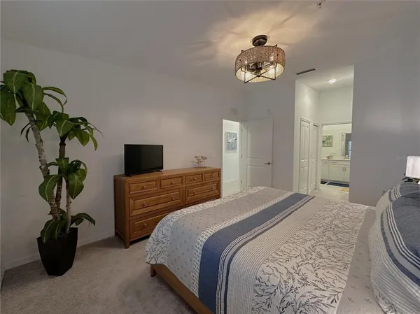 a bedroom with a bed and a chandelier