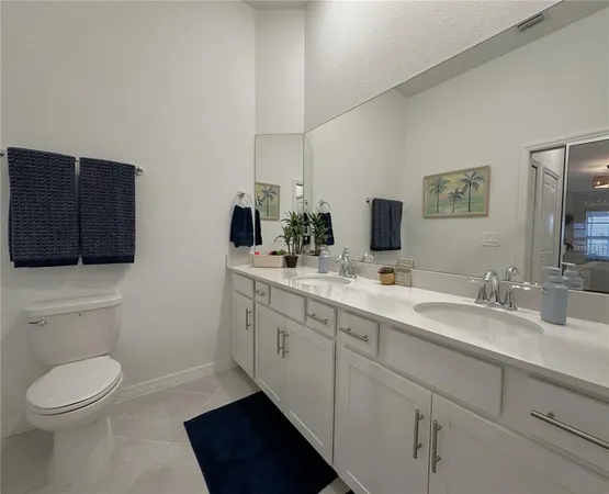 a bathroom with a toilet a sink a mirror and vanity