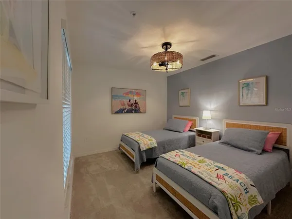 a bedroom with bed and a chandelier