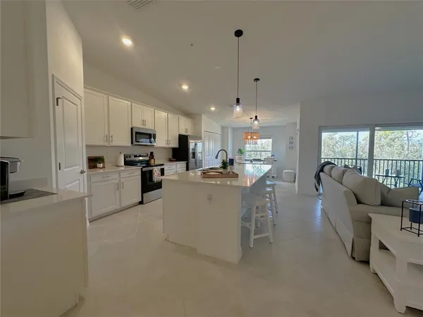 a living room with stainless steel appliances kitchen island furniture and a view of kitchen
