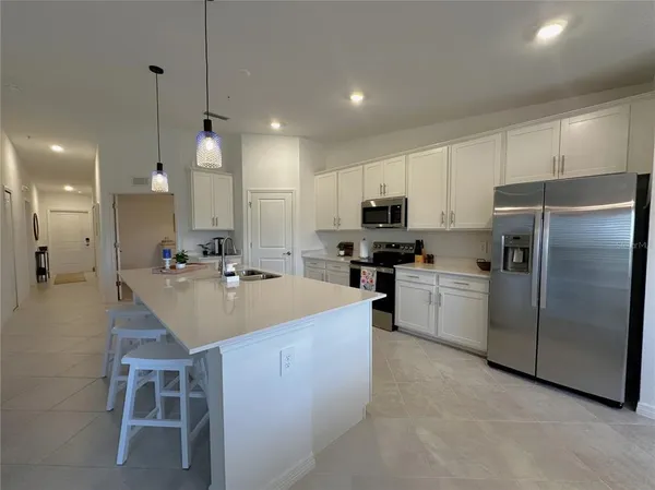 a kitchen with a sink stainless steel appliances and white cabinets