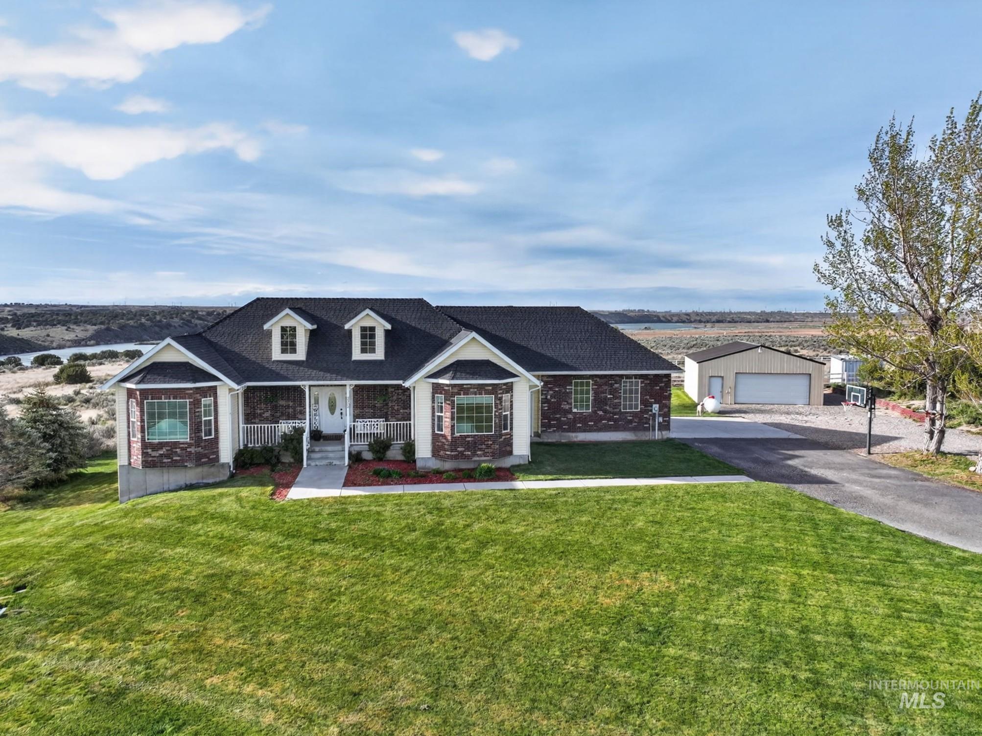 Brick and siding exterior with a covered porch, bay windows, and dormer accents