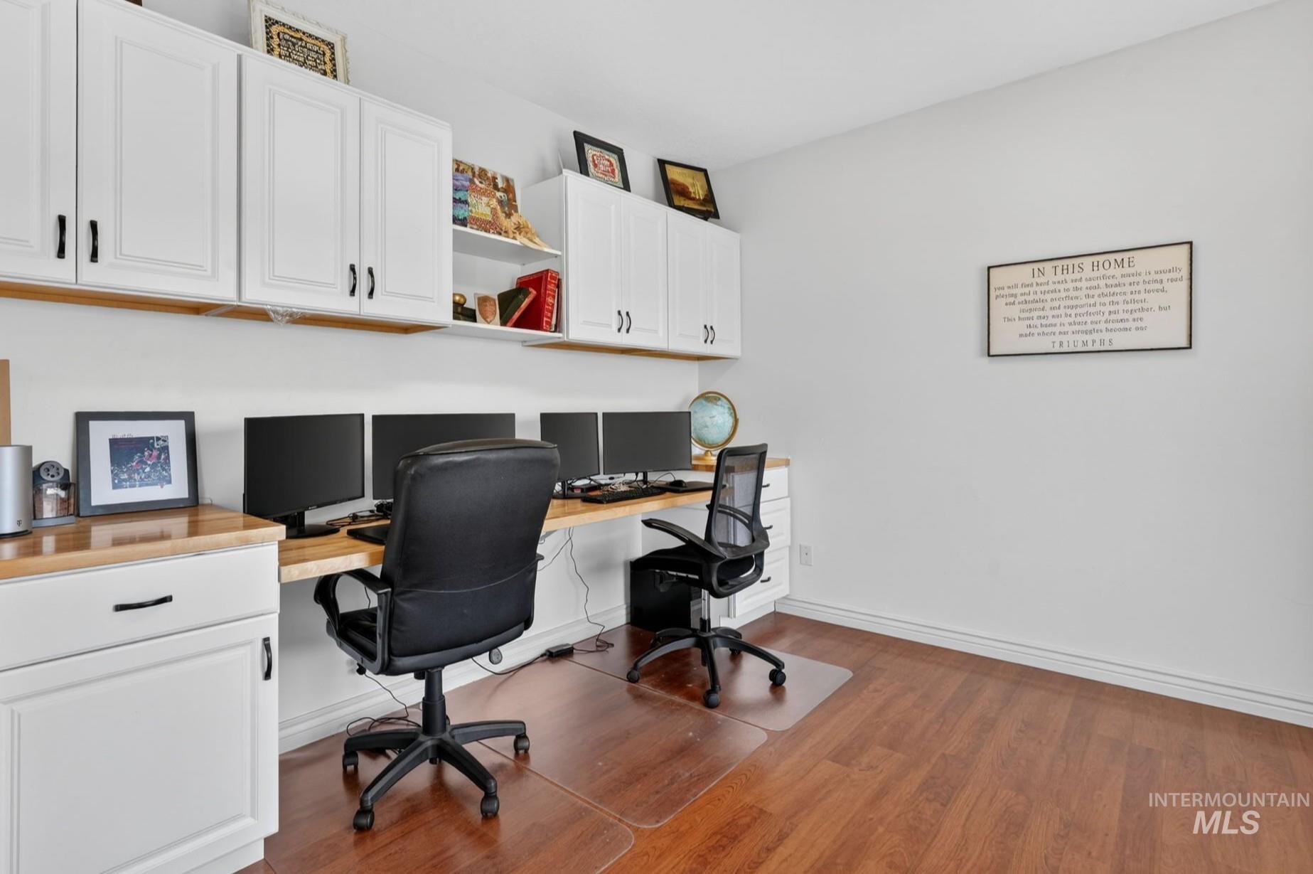 3352 Neeley Road American Falls, ID 83211 - Photo 15 of 43 Dedicated workspace featuring extensive built-in cabinetry, long wood-finish countertops, and wood-finish flooring