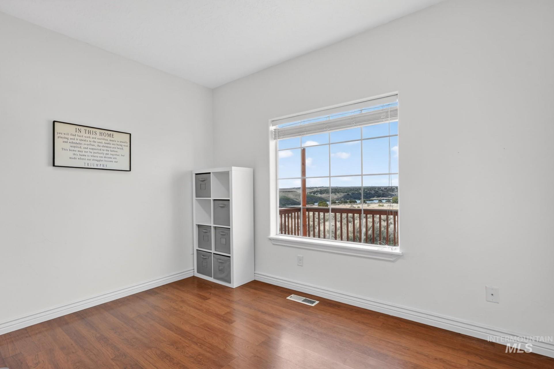 3352 Neeley Road American Falls, ID 83211 - Photo 16 of 43 Bright interior space with wood-finish flooring, white baseboards, and a large window offering expansive outdoor scenery