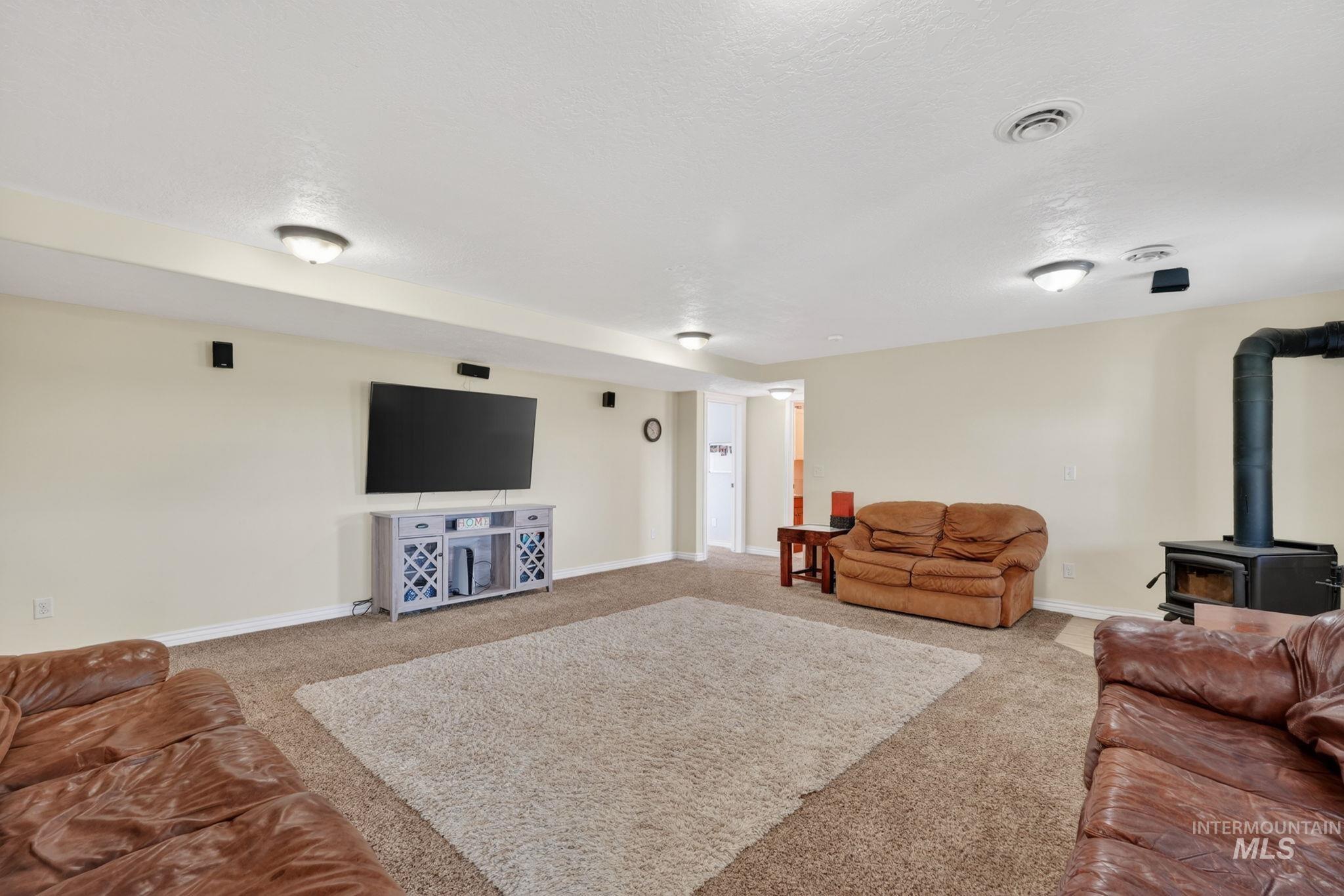 3352 Neeley Road American Falls, ID 83211 - Photo 23 of 43 Spacious entertainment room featuring recessed lighting, wall-mounted speakers, and wood fireplace