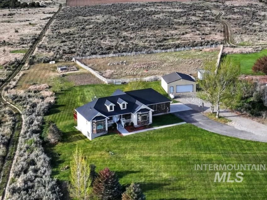 3352 Neeley Road American Falls, ID 83211 - Photo 32 of 43 Expansive property featuring a single-story residence with dormer windows, a detached auxiliary building, extensive manicured lawns, and a paved driveway