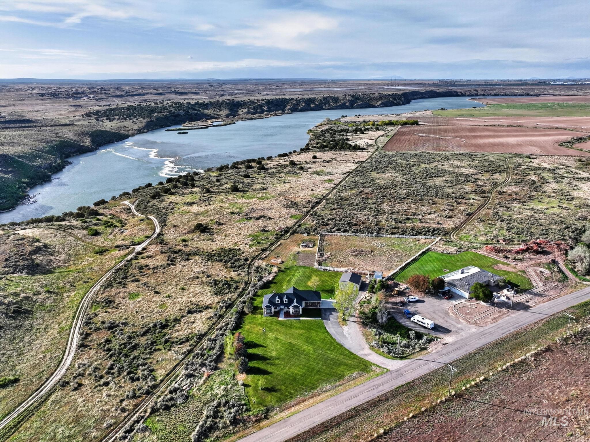 3352 Neeley Road American Falls, ID 83211 - Photo 34 of 43 Expansive property featuring a riverfront setting, residential structures, manicured lawn areas, a paved driveway, and agricultural land
