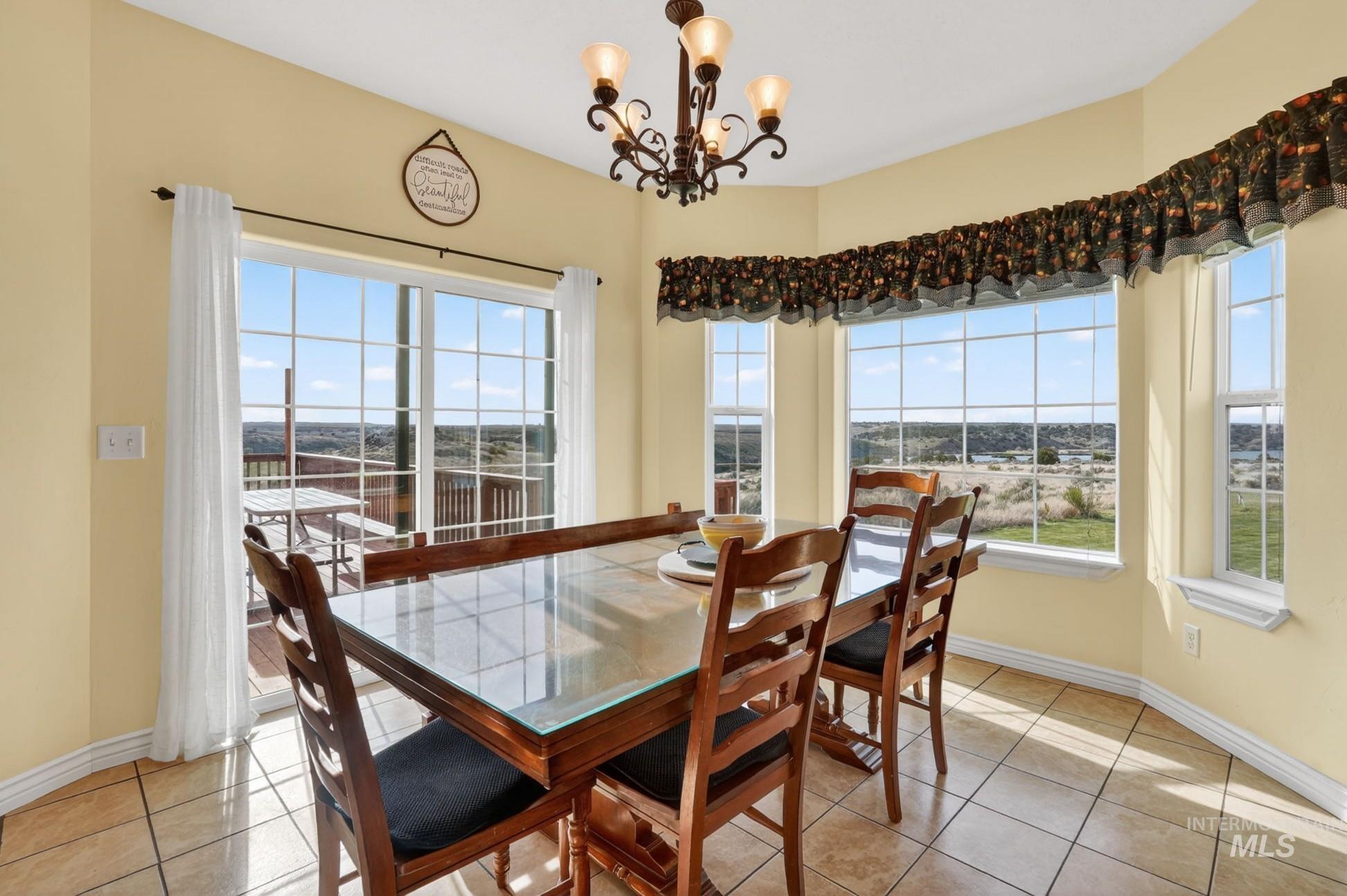 3352 Neeley Road American Falls, ID 83211 - Photo 9 of 43 Dining area featuring a bay window with multiple panes and a glass sliding door providing access to an exterior deck