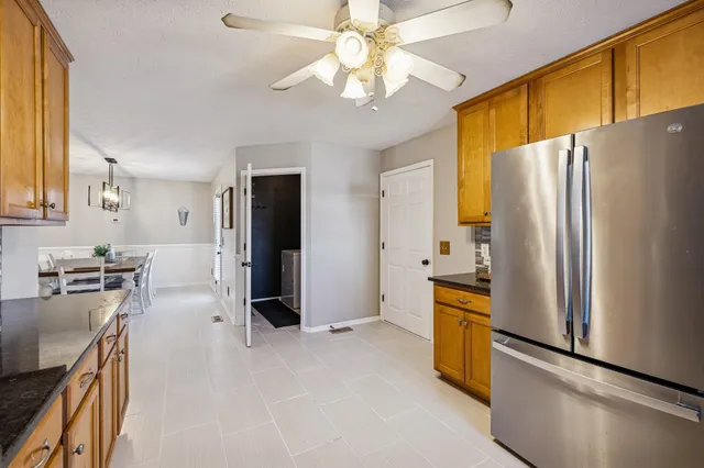 a kitchen with stainless steel appliances granite countertop a refrigerator a stove and a sink