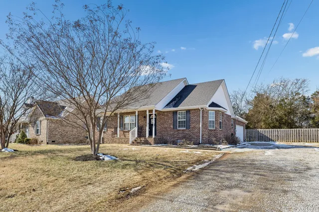a front view of a house with a yard covered in snow