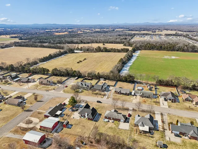 an aerial view of ocean and residential houses with outdoor space