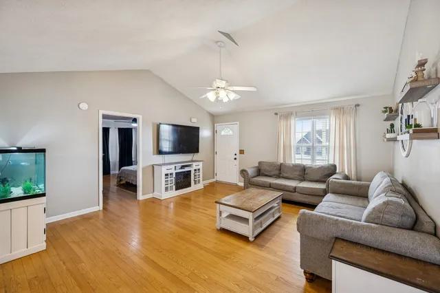 a living room with furniture a flat screen tv and a large window