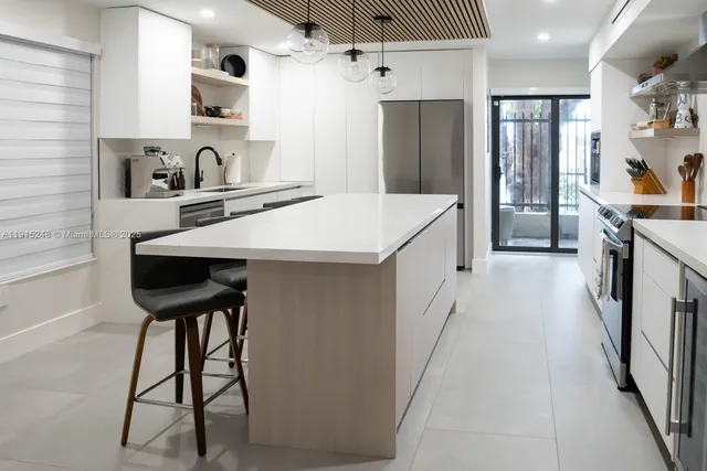a kitchen with stainless steel appliances a sink and a refrigerator