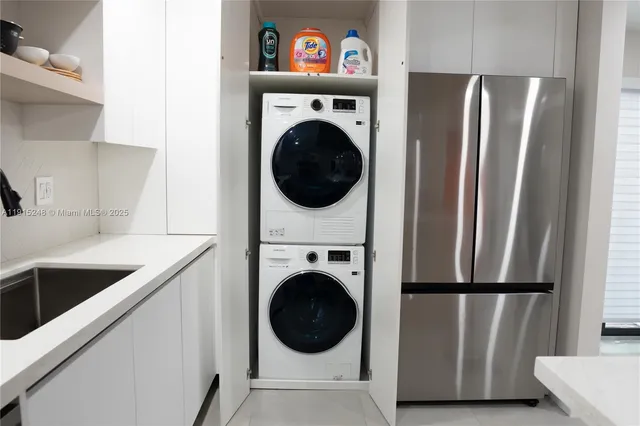a view of a kitchen with stainless steel appliances granite countertop a refrigerator and a sink