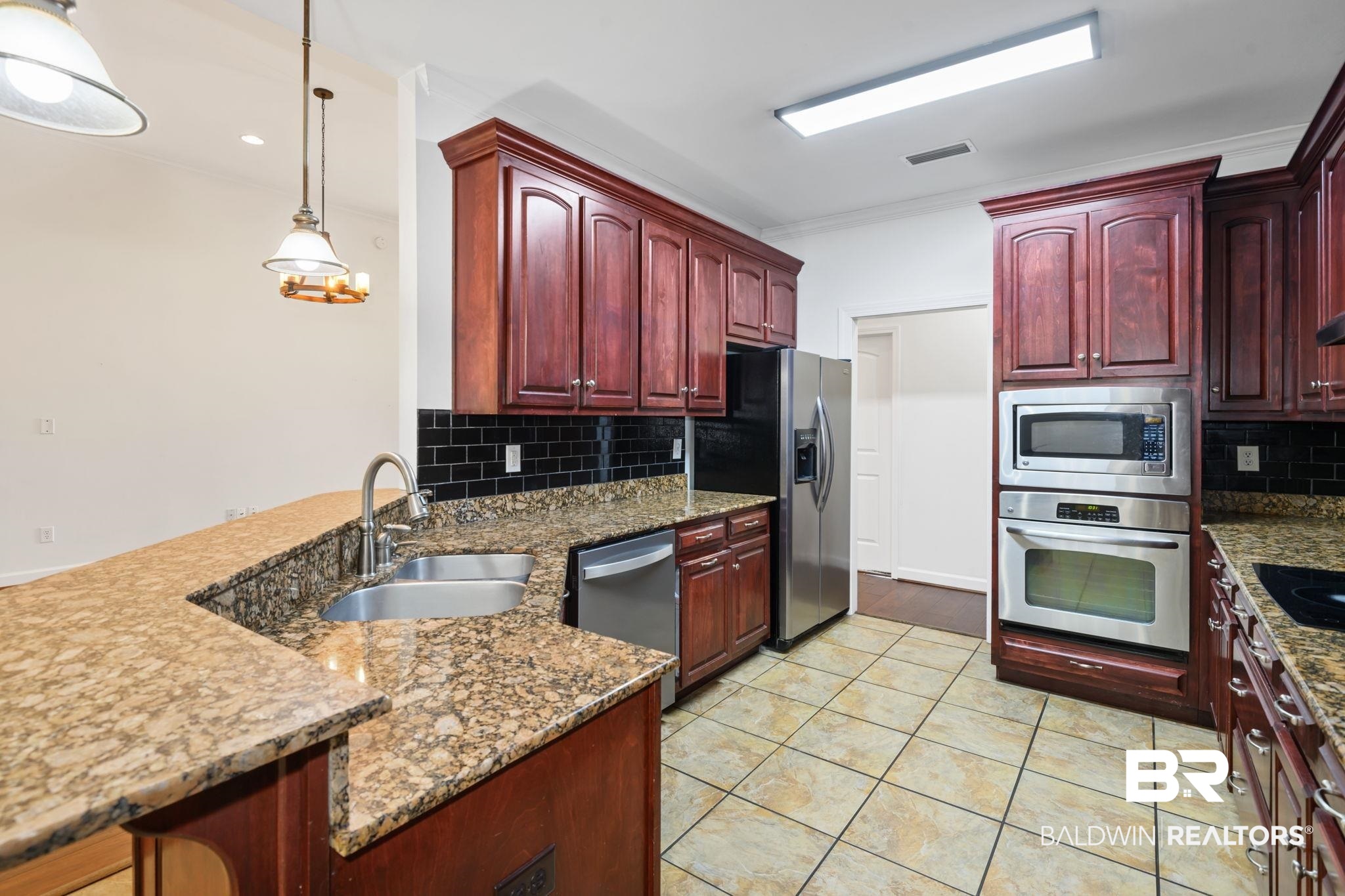 9730 Harmony Ridge Circle West Semmes, AL 36575 - Photo 8 of 38 Kitchen featuring stainless steel appliances, dark brown cabinets, a sink, a peninsula, and ornamental molding