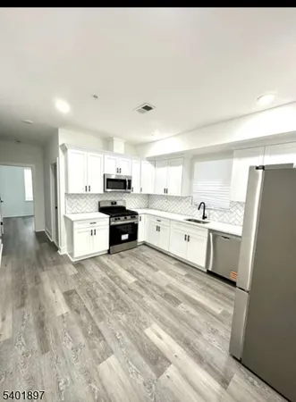 a large white kitchen with cabinets and a refrigerator