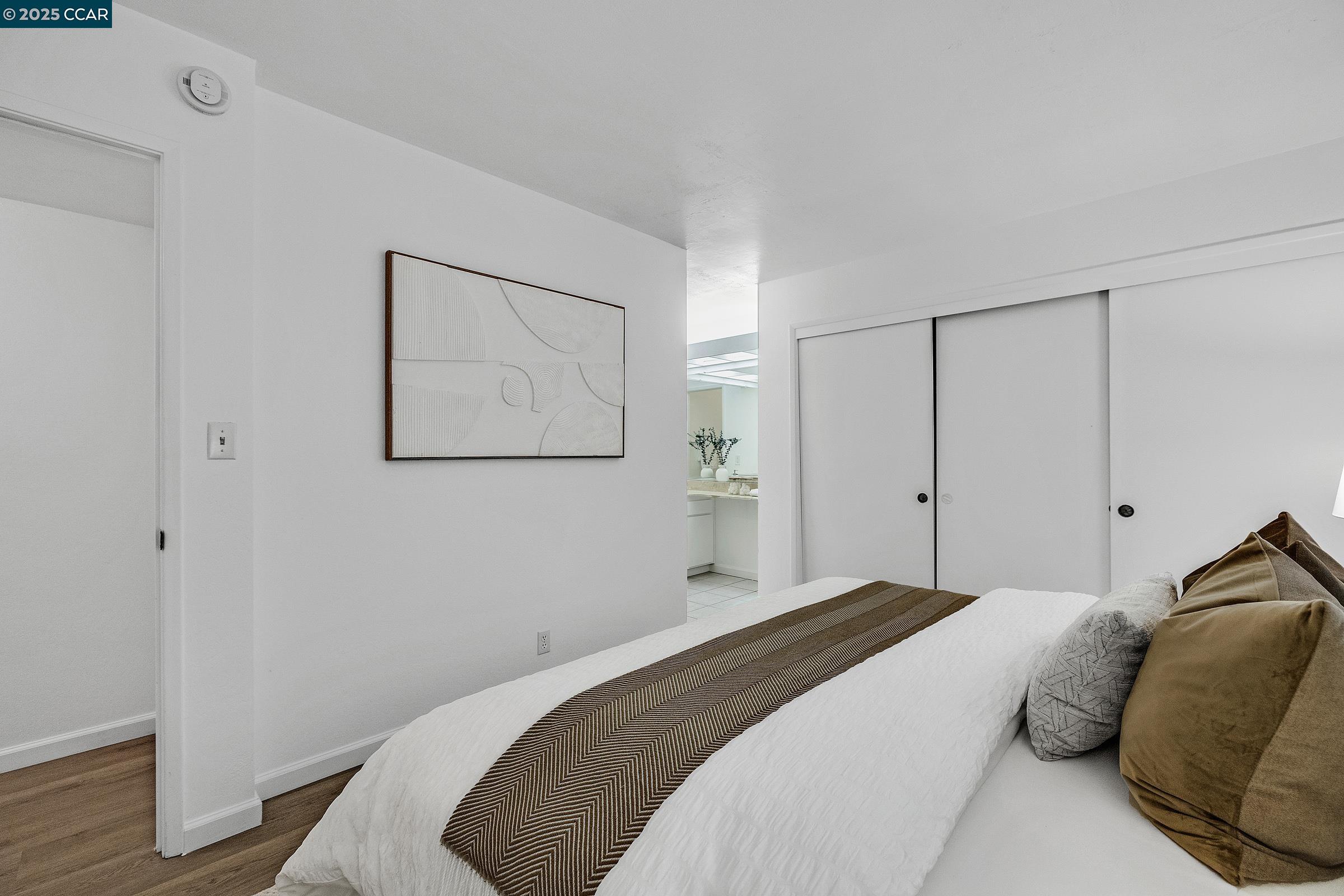 146 Ascot Court, Unit 2 Moraga, CA 94556 - Photo 17 of 33 a bedroom with a bed and a painting on the wall