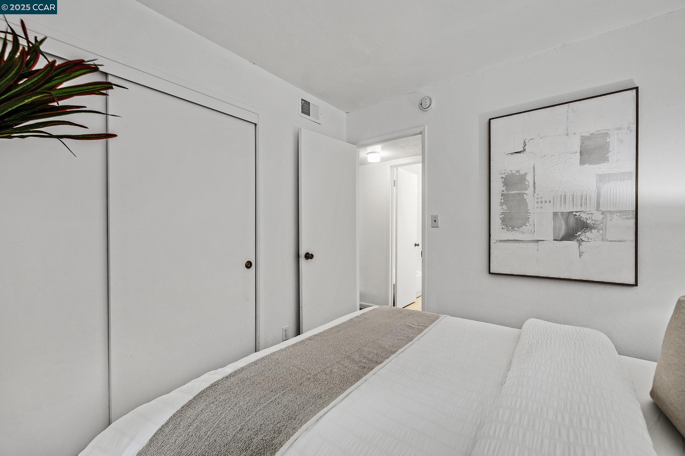 146 Ascot Court, Unit 2 Moraga, CA 94556 - Photo 19 of 33 a bedroom with a bed and a painting on the wall