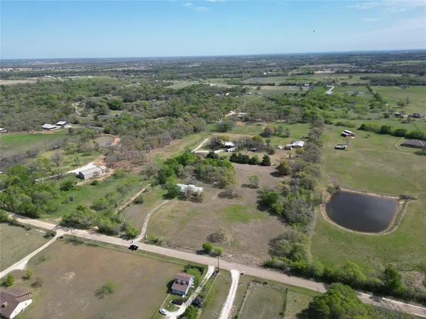 an aerial view of residential houses with outdoor space and trees