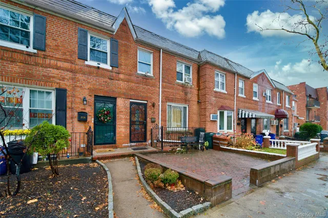 a view of a house with cars park side of the road