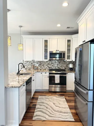 a view of a dining room with furniture a chandelier and wooden floor