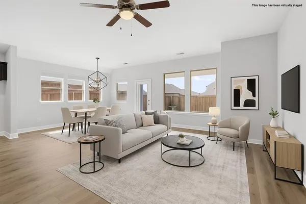 a living room with furniture a dining table and a large window