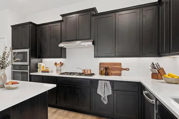 a large kitchen with stainless steel appliances kitchen island a large counter top and a stove top oven