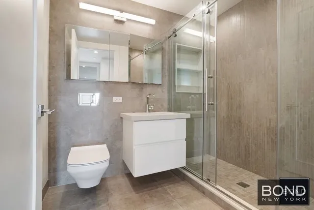 a bathroom with a sink a toilet and shower