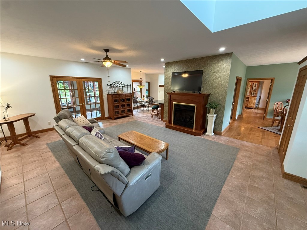 2178 Pleasant Valley Road Northeast New Philadelphia, OH 44663 - Photo 5 of 50 Living area featuring a fireplace, recessed lighting, ceiling fan, a skylight, and french doors