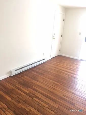 a view of an empty room with wooden floor